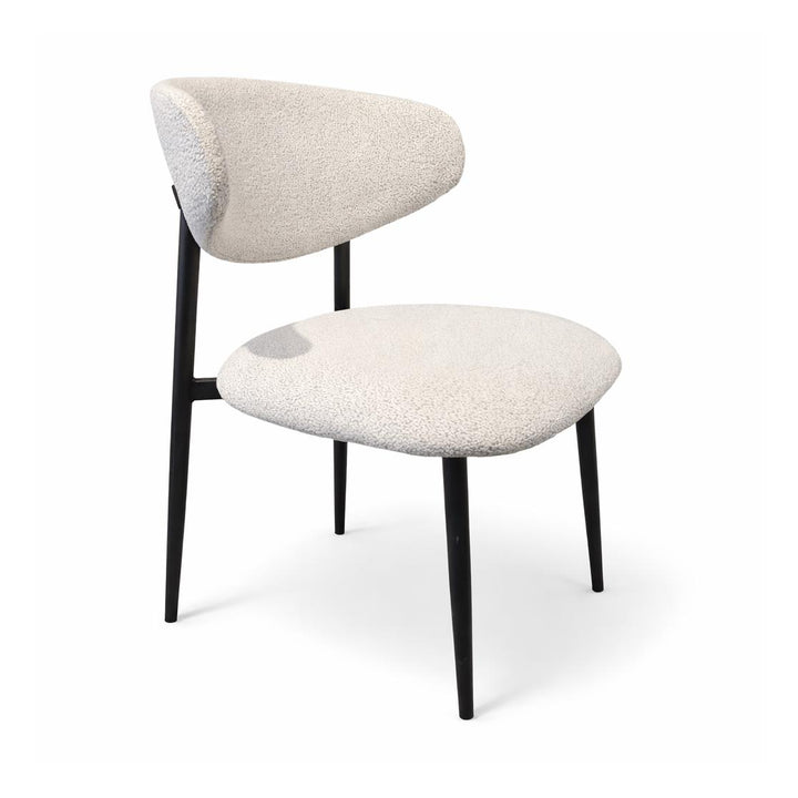 Curved beige boucle dining chair with slender black metal legs.