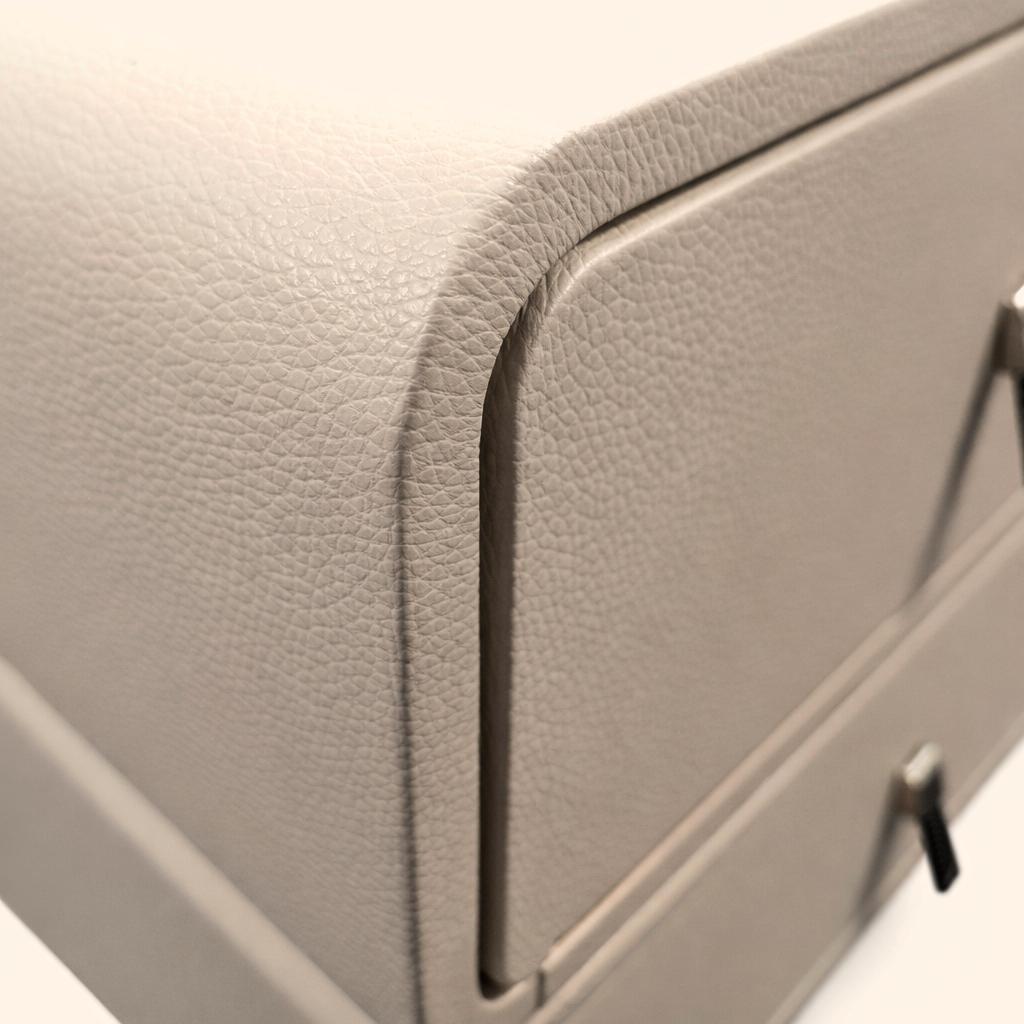 Close-up of a grey textured nightstand corner with silver metal drawer pulls.