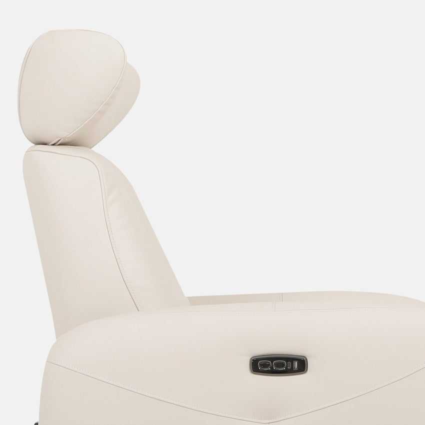 Close-up of a bisque leather sofa chair on a white background, showcasing the headrest and side controls.