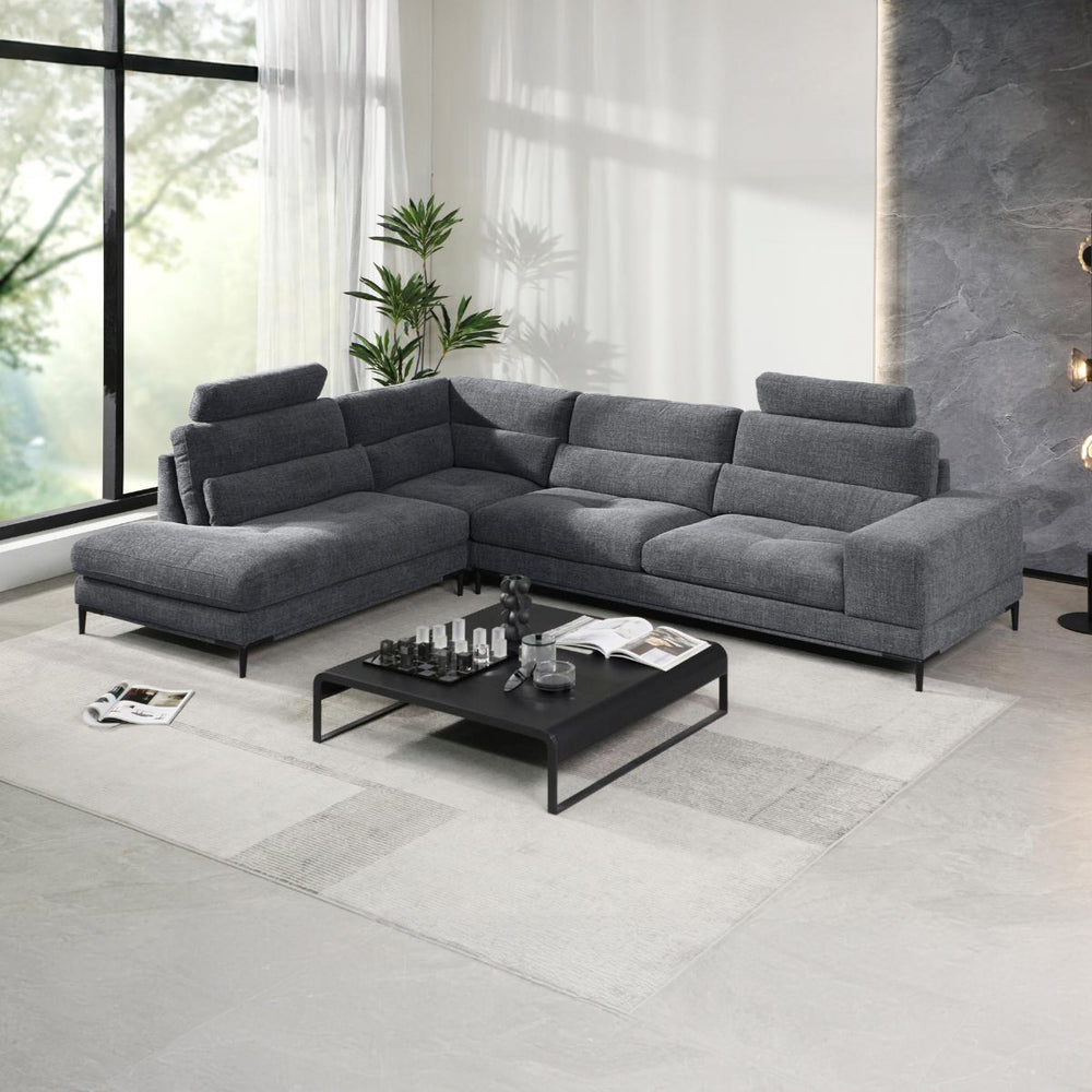 Grey textured fabric L-shaped sectional sofa with removable headrests and chaise lounge in a modern living room setting.