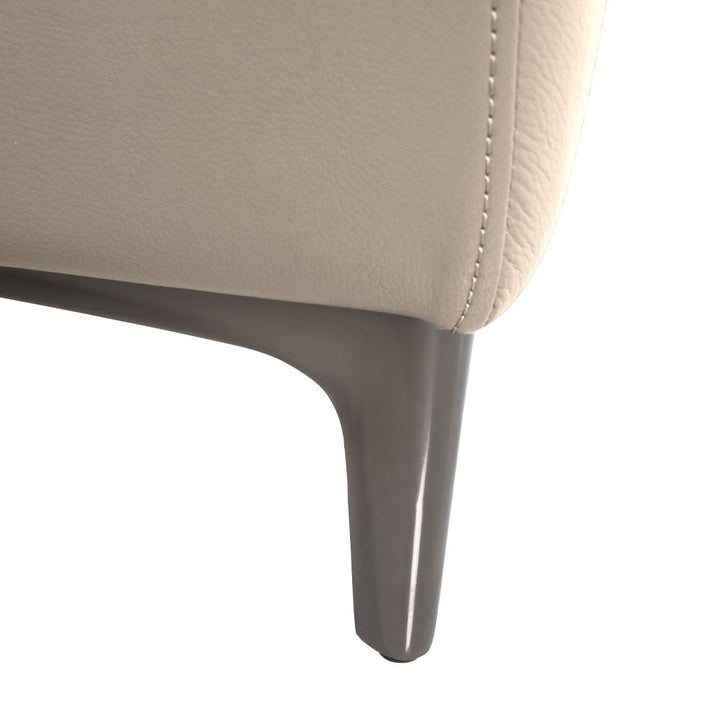 Close-up of the leg of a cream-colored leather sectional sofa on a white background.