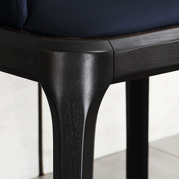 Close-up view of a dark wood chair frame and legs with a blue cushioned seat, showcasing the material and construction details.