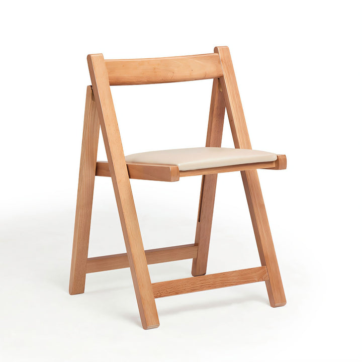 Light wood folding chair with a cream cushioned seat and minimalist X-frame design.
