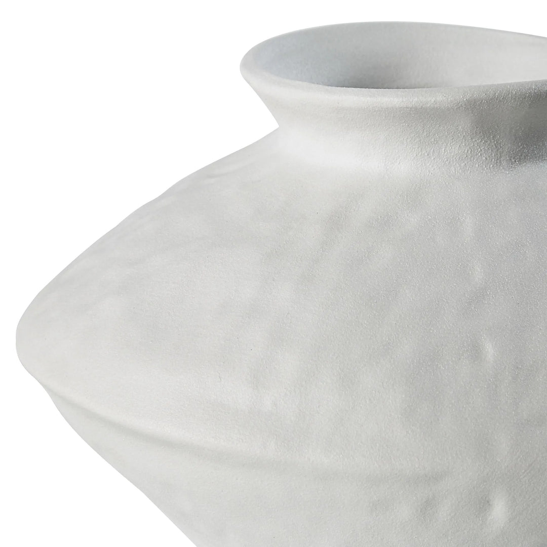 Close-up of a white ceramic vase with a textured surface against a white background.