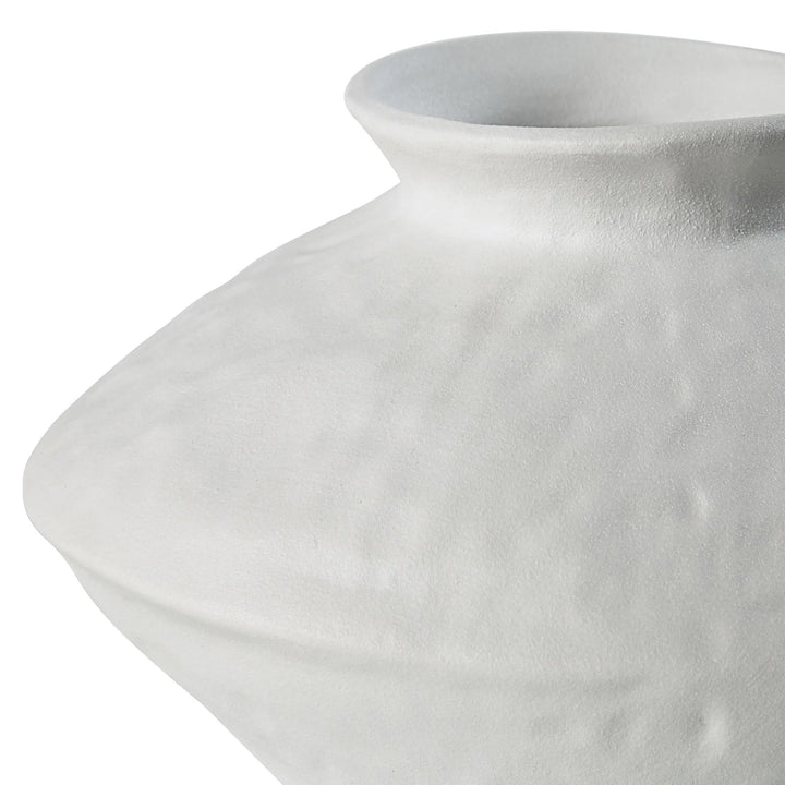 Close-up of a white ceramic vase with a textured surface against a white background.