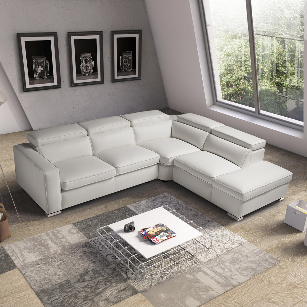 White leather L-shaped sectional sofa with chaise lounge and plush cushions in a modern living room.
