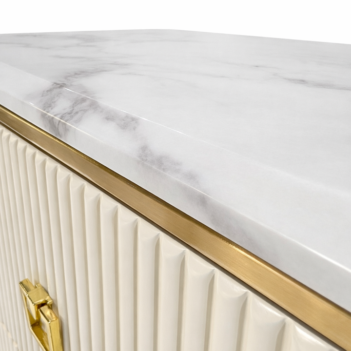 White marble-effect top with grey veining, gold trim, and cream fluted cabinet body with gold hardware.