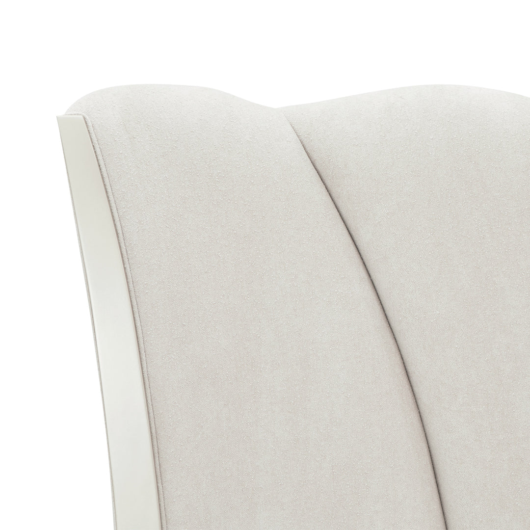 Close-up shot of a light beige textured fabric upholstered on furniture, with a white trim.