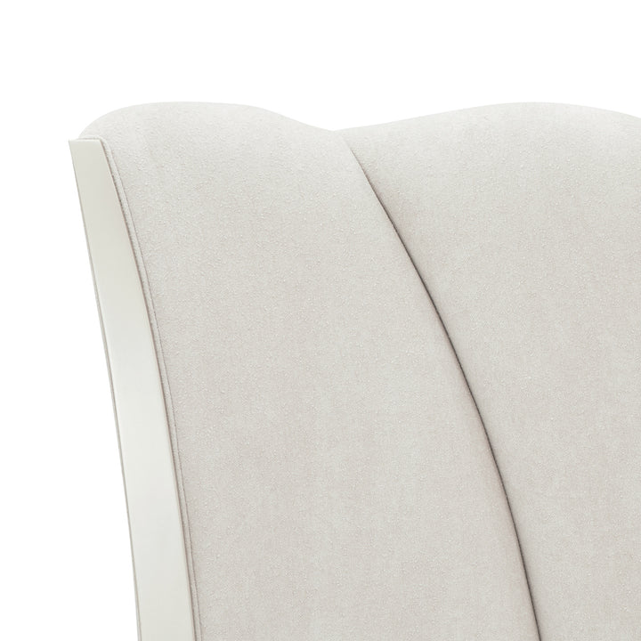 Close-up shot of a light beige textured fabric upholstered on furniture, with a white trim.