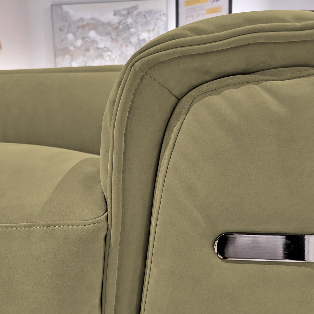 Close-up of a sage green upholstered sofa with plush armrests and a chrome handle.