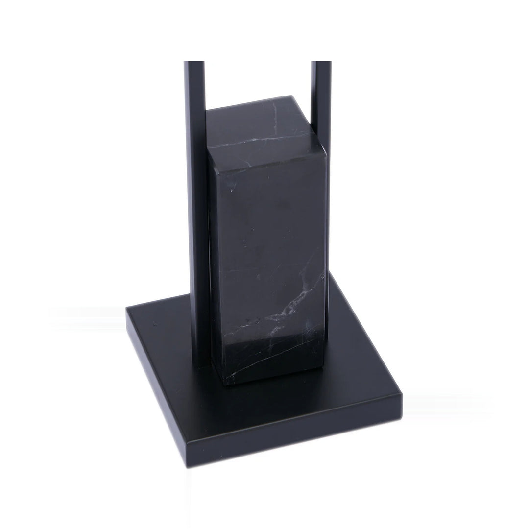 A black marble and metal sculpture on a white background.