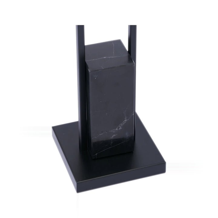 A black marble and metal sculpture on a white background.