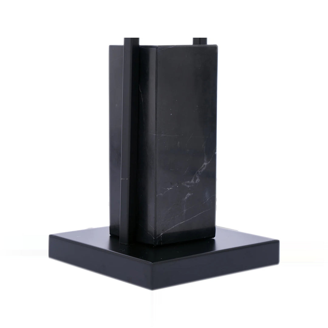 Image of a small, modern black marble sculpture or architectural model on a white background.