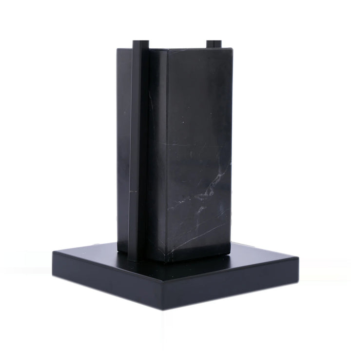 Image of a small, modern black marble sculpture or architectural model on a white background.