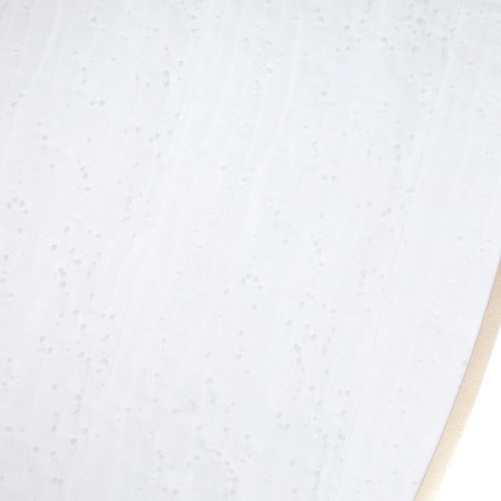Close-up shot of a white material with subtle patterns and a beige edge visible in the bottom right corner.