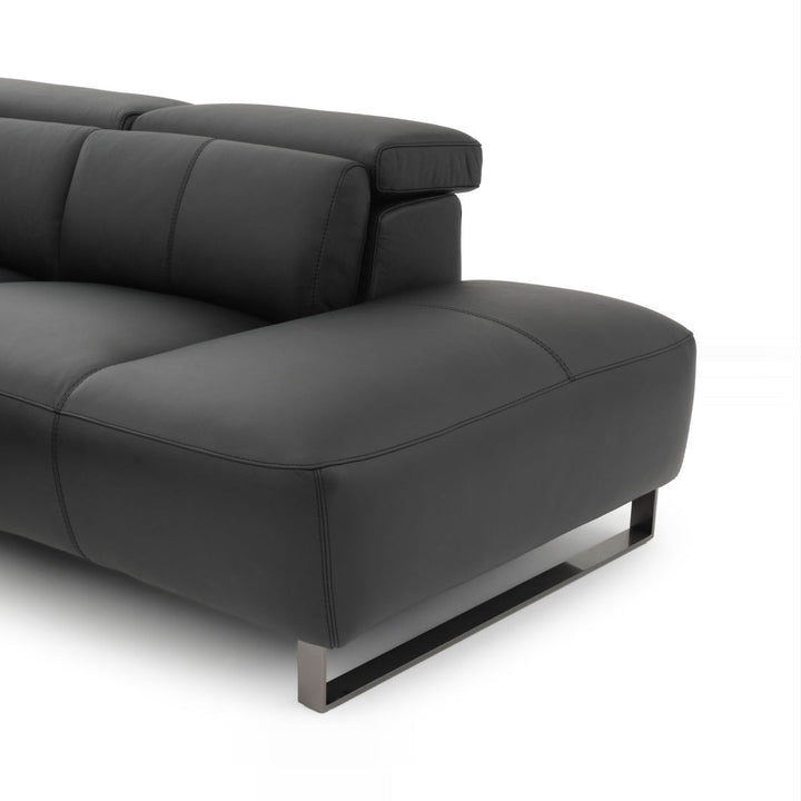 Close-up of a modern black leather sofa with adjustable headrests and metal legs, presented against a clean white background.