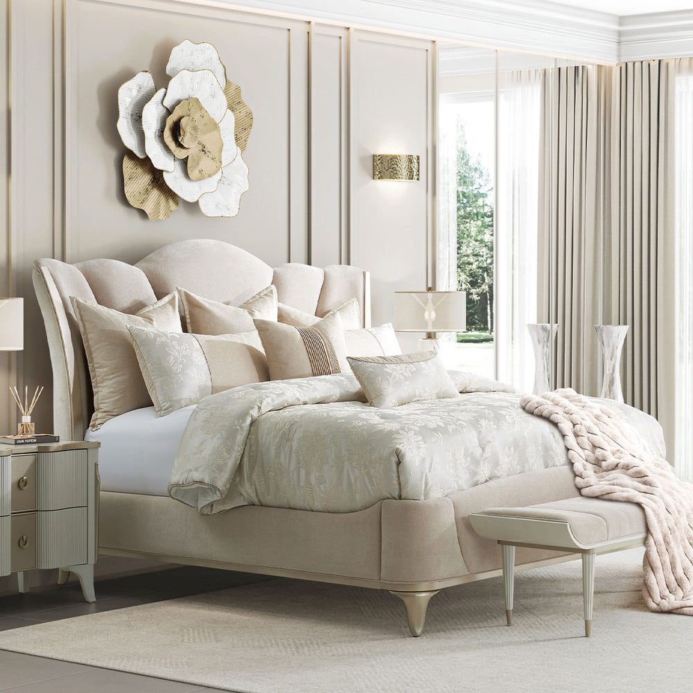 A luxurious bedroom scene featuring an upholstered bed with decorative pillows and a bench, set against a backdrop of elegant wall paneling, curtains, and decorative wall art.
