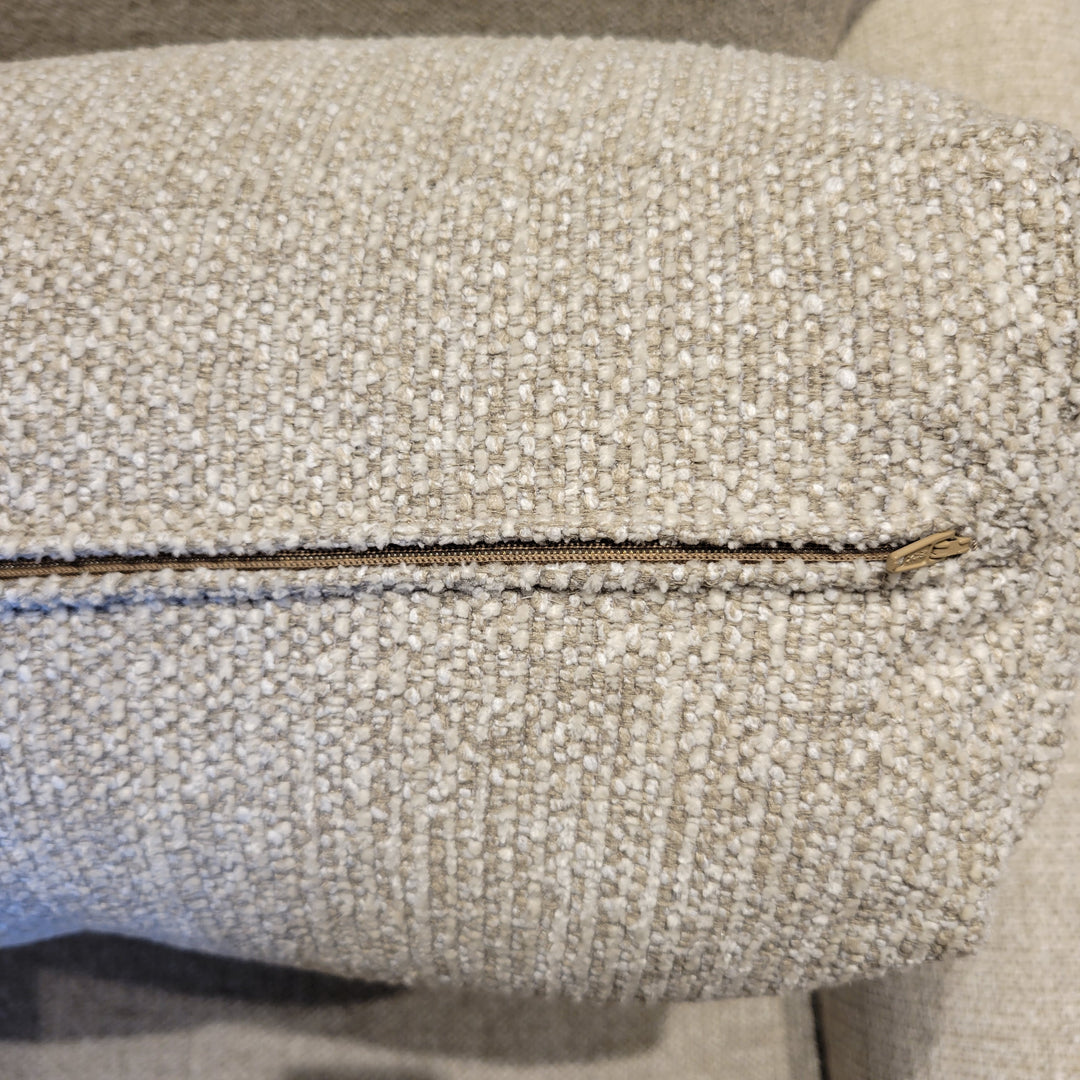 Close-up of a beige textured fabric with a zipper.