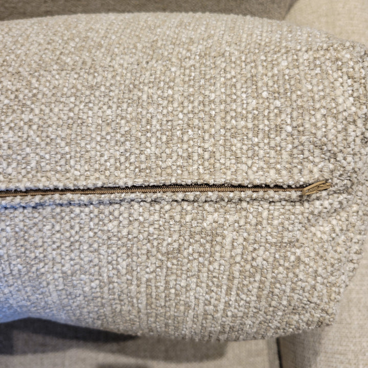 Close-up of a beige textured fabric with a zipper.