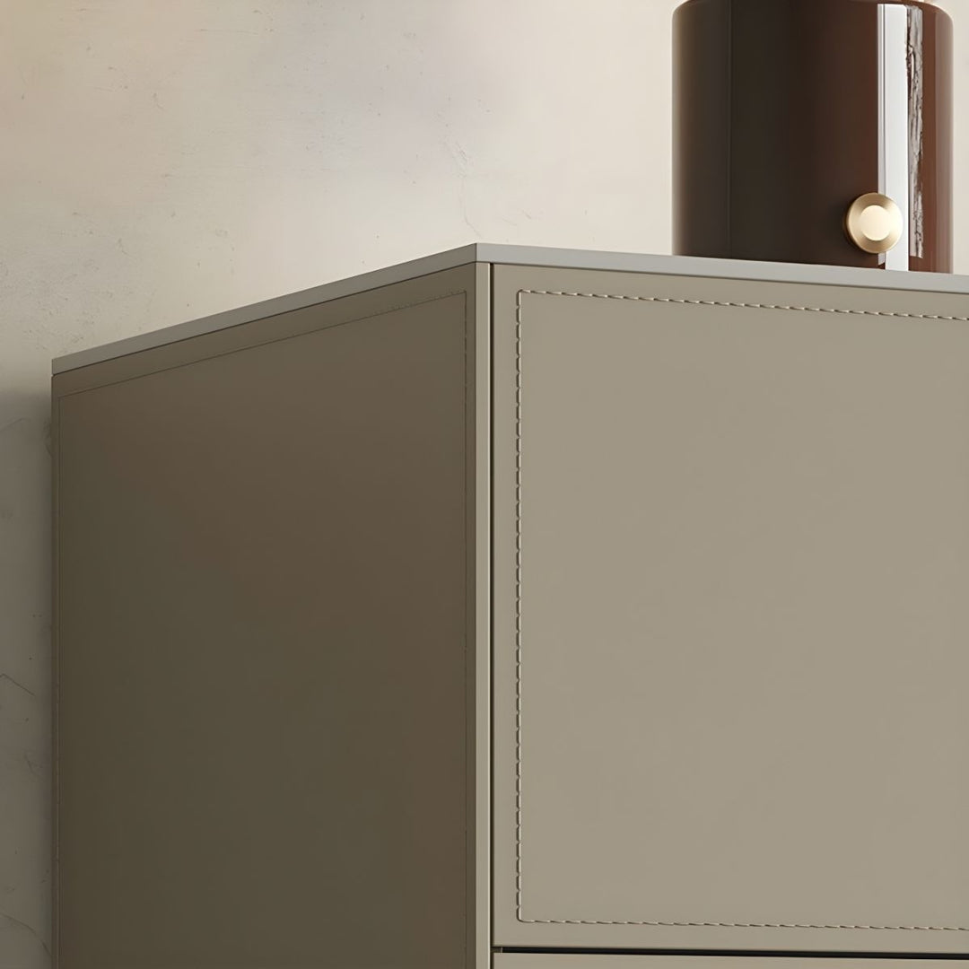A close-up view of a beige sideboard with stitched detailing, featuring a curved brown lamp with a gold accent on its top.