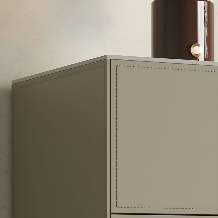 A close-up view of a beige sideboard with stitched detailing, featuring a curved brown lamp with a gold accent on its top.