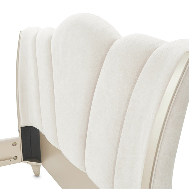 Close-up of a white upholstered headboard on a white background, showcasing its ribbed design and light-colored trim.
