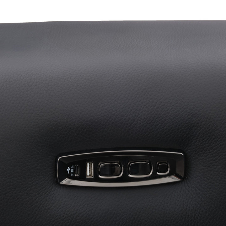 Close-up of black leather upholstery and a control panel with USB ports and buttons.