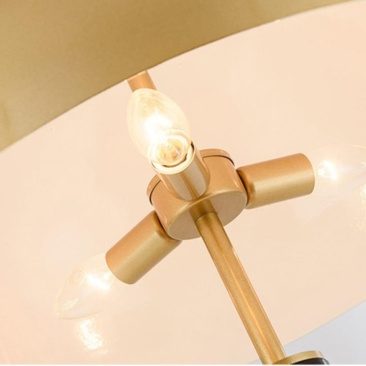 Close-up view of a gold-colored lamp showing the lamp's material and light bulbs.