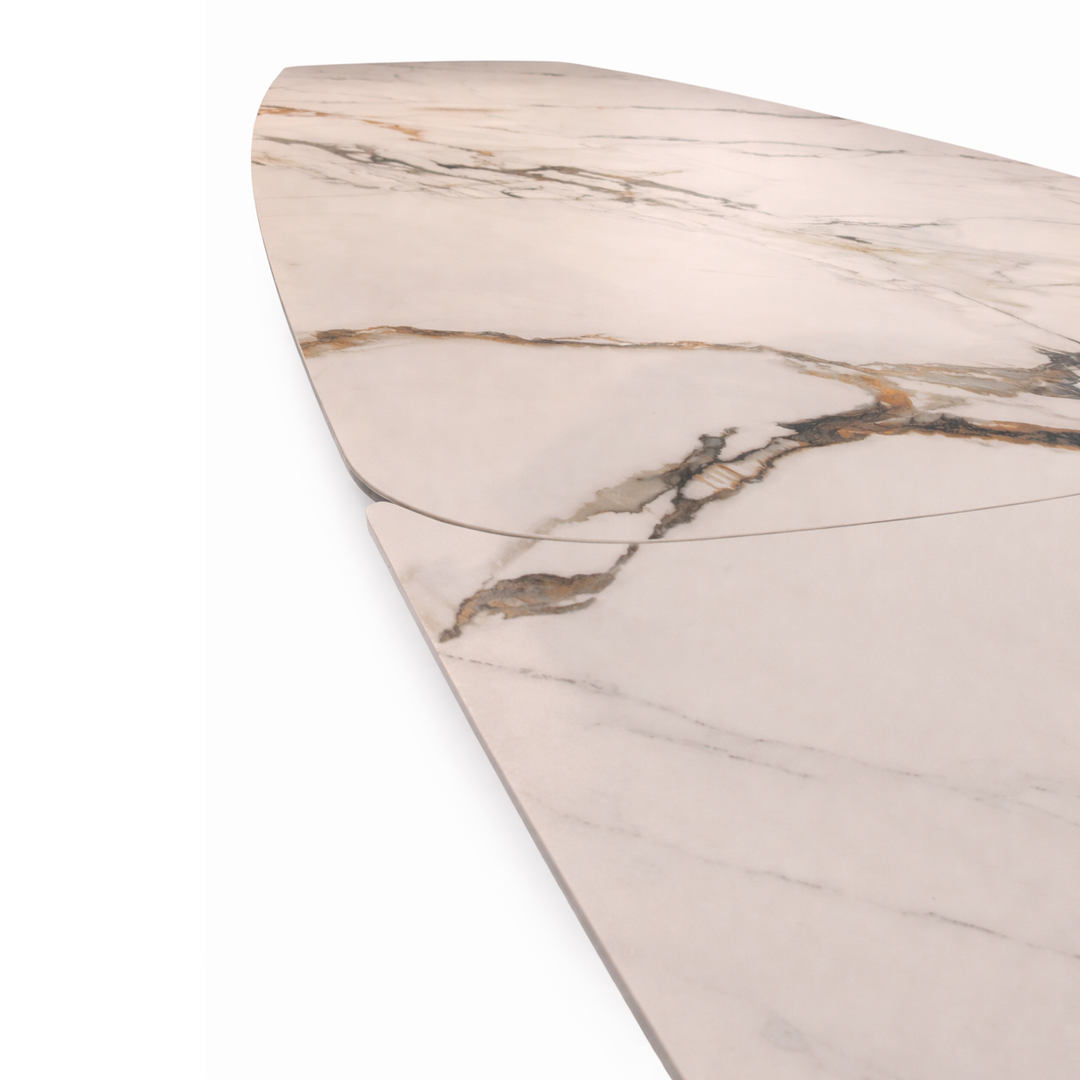 Close-up of a white marble table top with gold and grey veining and a visible extension seam.