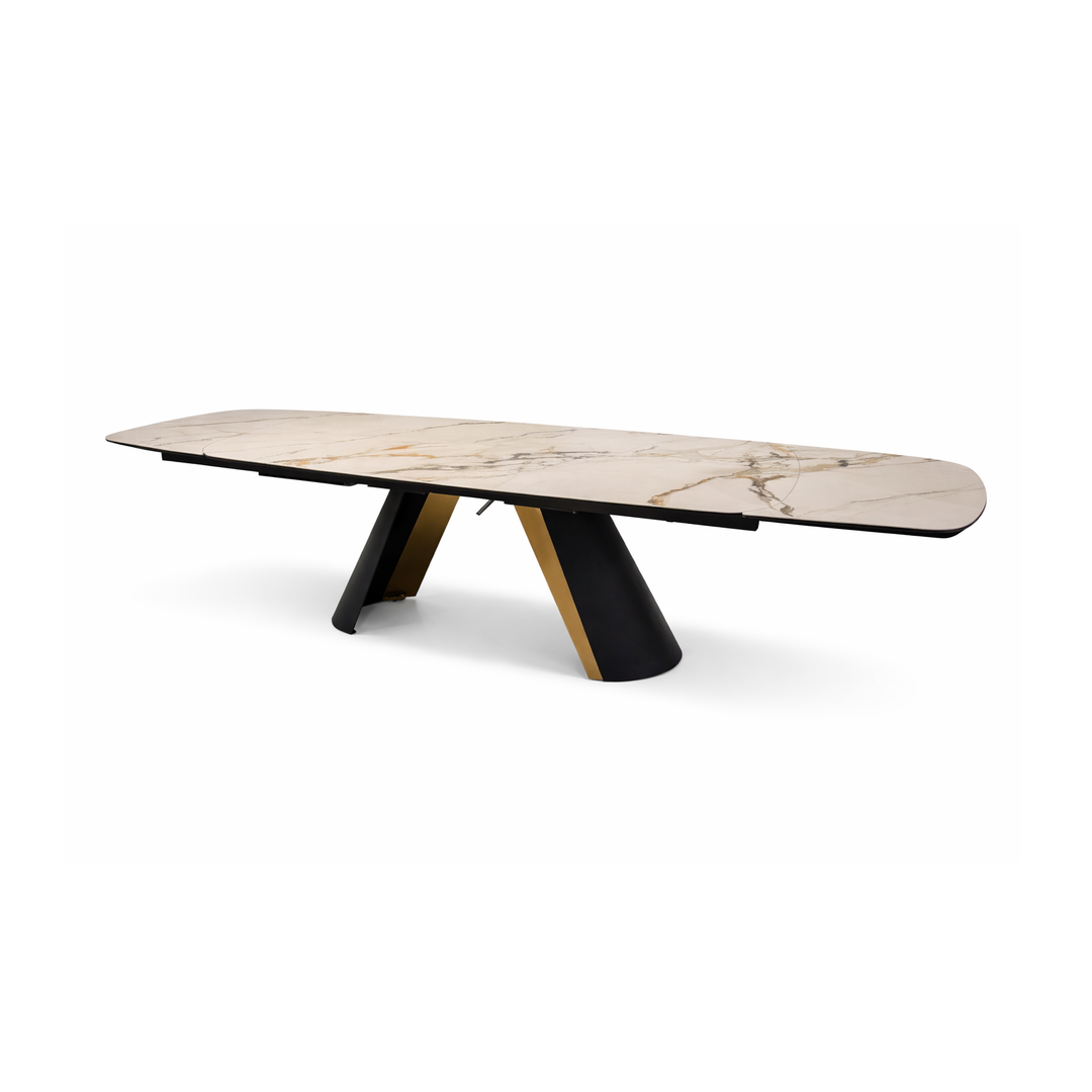 Rectangular dining table with cream marble top and black and gold V-shaped base.