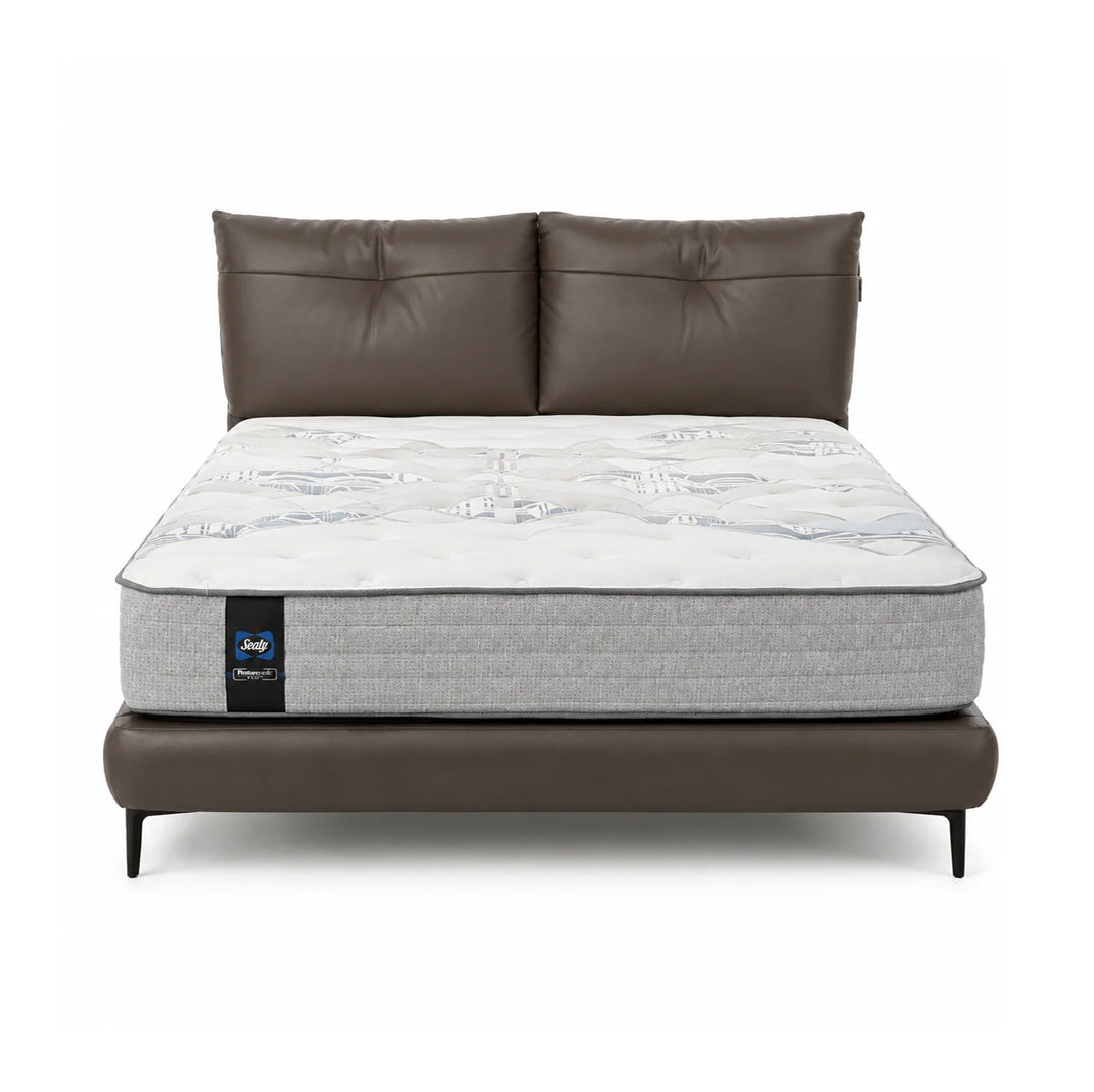 A luxury mattress on a matching brown faux-leather bed frame with a tufted headboard, shown against a solid white background.